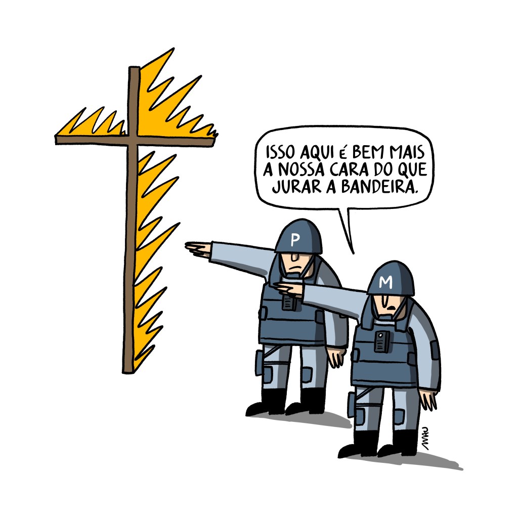 charge: dois policiais estão fazendo a saudação nazista em frente a uma cruz pegando fogo. Um deles diz ao outro, “Isso aqui é bem mais a nossa cara do que jurar a bandeira.”